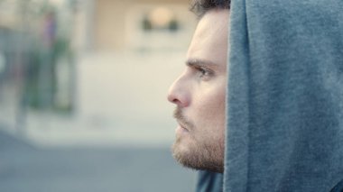 Young caucasian man standing wearing hoodie with serious expression at street