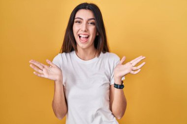 Sarı arka planda duran genç ve güzel bir kadın çılgın ve başarıyı kollarını kaldırıp heyecanla haykırarak kutluyor. Kazanan konsept 