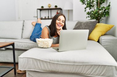 Evde patlamış mısır yiyen genç ve güzel bir İspanyol kadın.