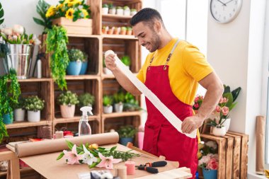Çiçekçiye dantel tutan kendine güvenen İspanyol bir çiçekçi.