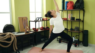 Orta yaşlı İspanyol kadın spor merkezinde yoga eğitimi alıyor.