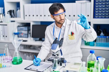 Genç İspanyol bilim adamı, laboratuardaki panoya yazı yazmış.