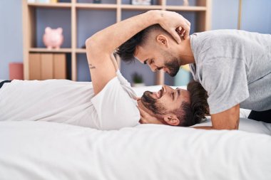Young couple hugging each other lying on bed at bedrooom