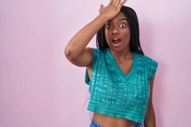 Pembe arka planda dikilen örgülü genç Afro-Amerikan hatayı unutmamak için el ele tutuşarak şaşırdı. Unuttum, kötü hafıza kavramı. 