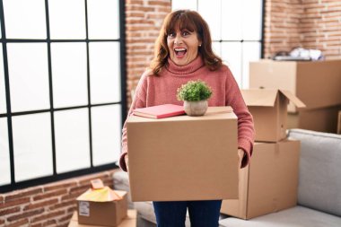 Orta yaşlı İspanyol kadın elinde karton bir kutuyla yeni bir eve taşınıyor. Çılgınlığı kutluyor ve başarıya hayret ediyor. Gözleri açık, heyecanlı çığlıklar atıyor.. 