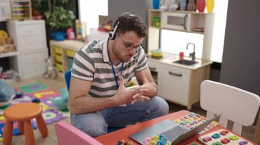 Young caucasian man on a video call working as teacher at kindergarten