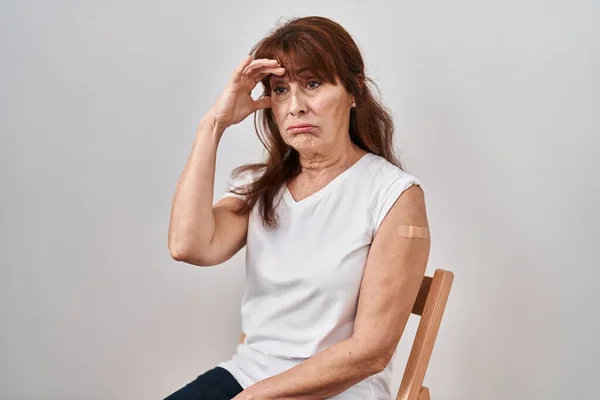 中年惊慌失措的女人得到了用创可贴显示胳膊的疫苗 她担心并强调了手头上的问题 紧张和对危机的焦虑 — 图库照片