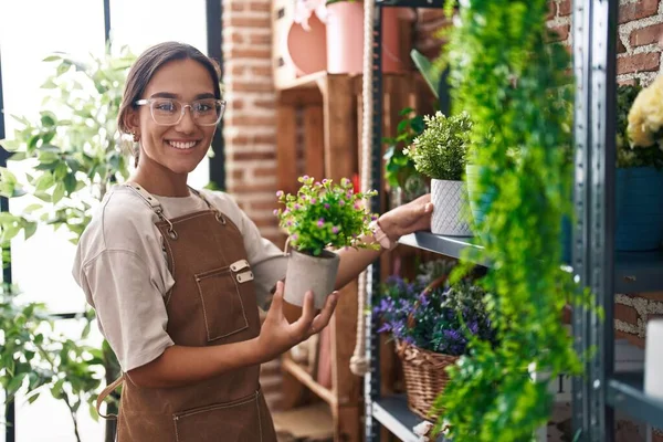 stock image Young beautiful hispanic woman florist holding plant at florist