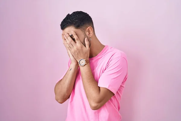 泣きながら手で顔を覆う悲しい表情でピンクの背景に立っているヒスパニック系の若者 うつ病の概念 — ストック写真
