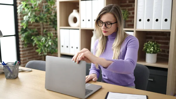 使用笔记本电脑在办公室工作的年轻金发女商人 — 图库照片