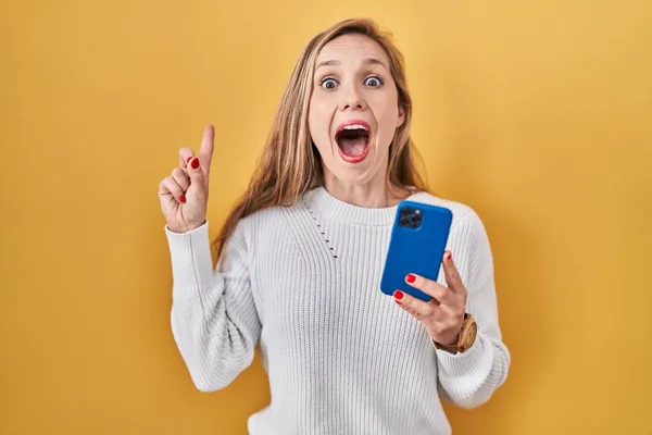 Jovem Loira Usando Mensagem Digitação Smartphone Sorrindo Surpreso Surpreso Apontando — Fotografia de Stock