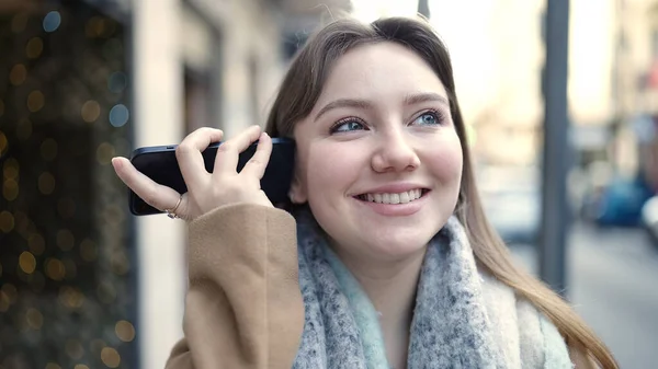 stock image Young blonde woman smiling confident listening audio message by the smartphone at street