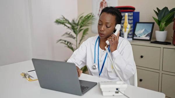 Medico Afroamericano Donna Utilizzando Computer Portatile Parlando Telefono Clinica — Foto Stock