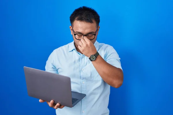 コンピュータのラップトップを使用して中国の若い男が疲れ鼻や目をこすり疲労や頭痛を感じている ストレスとフラストレーションの概念 — ストック写真