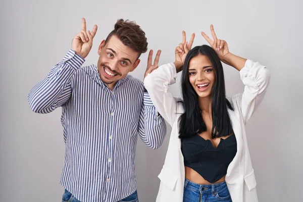 Young Hispanic Couple Standing White Background Posing Funny Crazy Fingers —  Fotos de Stock