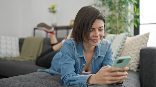 Jonge Kaukasische Vrouw Met Behulp Van Smartphone Liggend Bank Thuis — Stockfoto