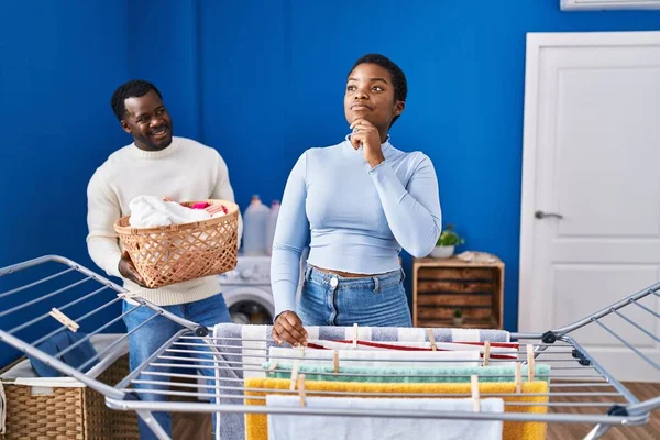 Young African American Couple Hanging Clothes Clothesline Serious Face Thinking — Stock Photo, Image