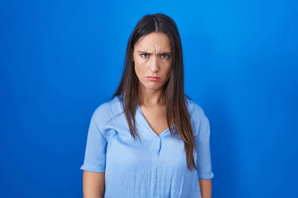 Jonge Brunette Vrouw Staat Blauwe Achtergrond Sceptisch Nerveus Fronsen Boos — Stockfoto