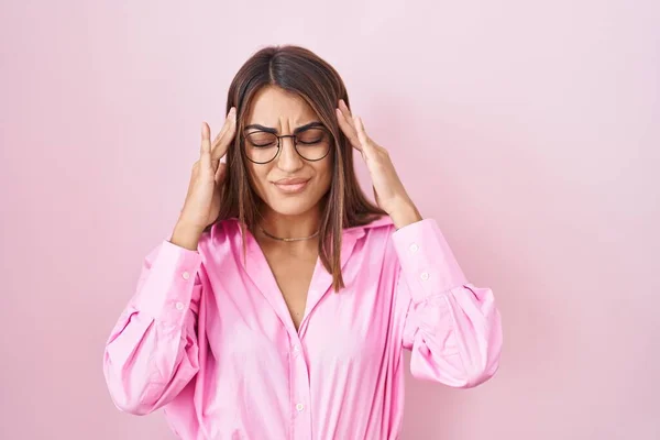 年轻的惊慌失措的女人戴着眼镜站在粉红的背景上 手托着头 头疼是因为压力 偏头痛 — 图库照片