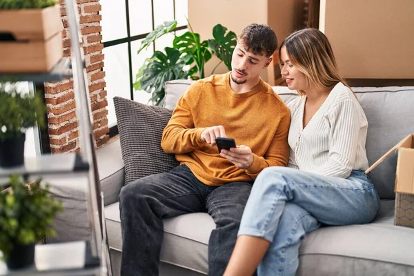 Junger Mann Und Junge Frau Sitzen Mit Smartphone Auf Sofa — Stockfoto