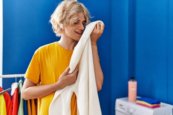Mladý Blond Muž Usmívá Sebevědomě Vonící Oblečení Prádelně — Stock fotografie