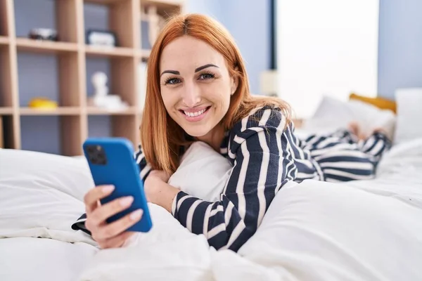 Νεαρή Καυκάσια Γυναίκα Που Χρησιμοποιεί Smartphone Ξαπλωμένη Στο Κρεβάτι Στο — Φωτογραφία Αρχείου