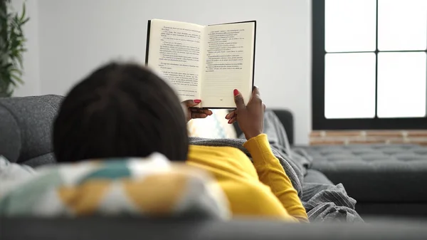 African Woman Reading Book Lying Sofa Home —  Fotos de Stock