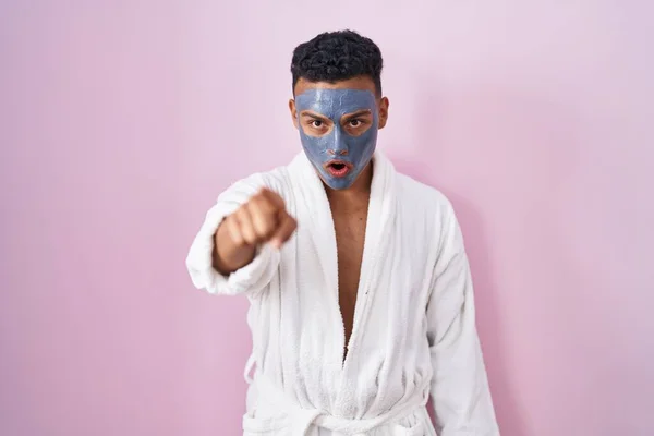 Young Hispanic Man Wearing Beauty Face Mask Bath Robe Pointing — Stock Photo, Image