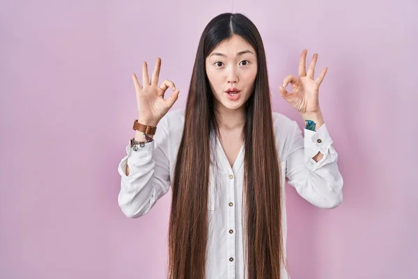 분홍색 중국인젊은 여성은 놀랍고 충격받은 표정으로 손가락으로 괜찮은 승인의 상징을 — 스톡 사진