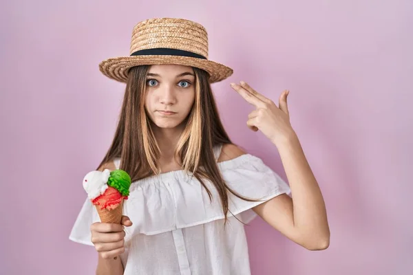 十代の少女はアイスクリームの撮影を保持し 銃のように頭に手と指を指して自分自身を殺す 自殺のジェスチャー — ストック写真