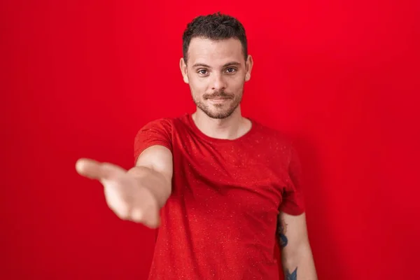 Junger Hispanischer Mann Steht Über Rotem Hintergrund Und Lächelt Fröhlich — Stockfoto