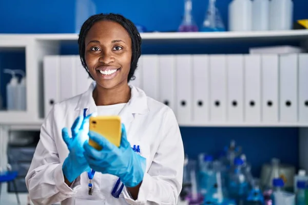 アフリカ系アメリカ人女性はスマートフォンの研究室で科学者の制服を着て — ストック写真