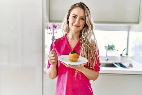 Junge Frau Lächelt Zuversichtlich Und Hält Cupcake Der Küche — Stockfoto