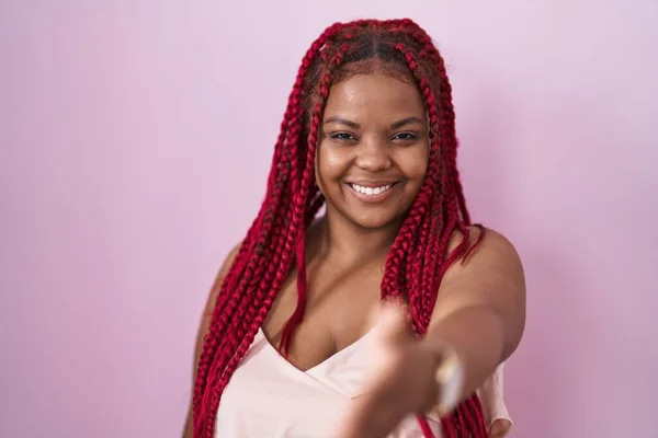 Африканская Американка Плетеными Волосами Стоящими Розовом Фоне Улыбаясь Дружелюбно Предлагая — стоковое фото