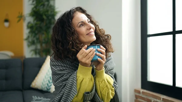 Middle Age Hispanic Woman Drinking Coffee Sitting Sofa Home — Zdjęcie stockowe