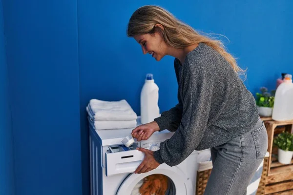 Genç Sarışın Kadın Gülümsüyor Çamaşır Odasında Çamaşır Makinesine Deterjan Döküyor — Stok fotoğraf
