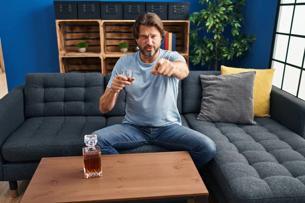 Handsome Middle Age Man Drinking Glass Whiskey Sitting Sofa Pointing — Stock Photo, Image