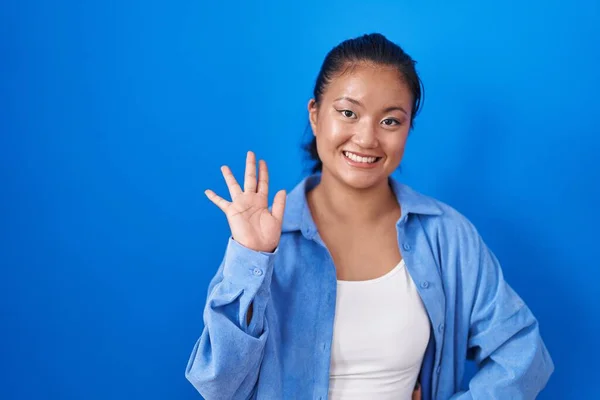 Aziatisch Jong Vrouw Staande Blauwe Achtergrond Ontheffing Zeggen Hallo Gelukkig — Stockfoto