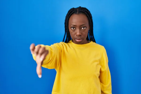 Mooie Zwarte Vrouw Staat Blauwe Achtergrond Kijken Ongelukkig Boos Tonen — Stockfoto