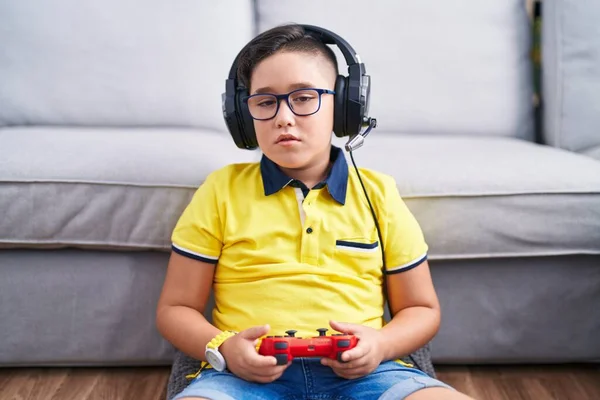 lazy teenager boy play computer games, sit in headphones, looking at screen  of laptop, free time at home Stock Photo