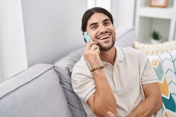 Young Hispanic Man Talking Smartphone Sitting Sofa Home — Stockfoto