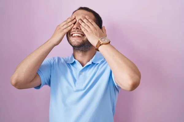 Латиноамериканець Стоїть Над Рожевим Фоном Закриваючи Очі Усміхненими Веселими Кумедними — стокове фото