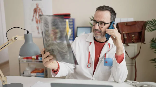 Orta Yaşlı Doktor Akıllı Telefondan Konuşuyor Klinikte Röntgen Çekiyor — Stok fotoğraf