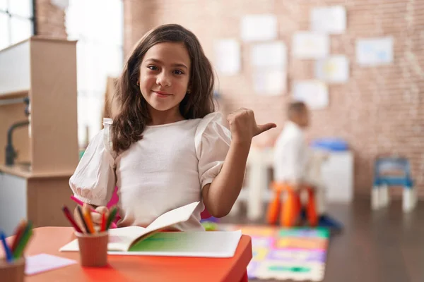 Pequena Menina Hispânica Pintando Escola Apontando Polegar Até Lado Sorrindo — Fotografia de Stock