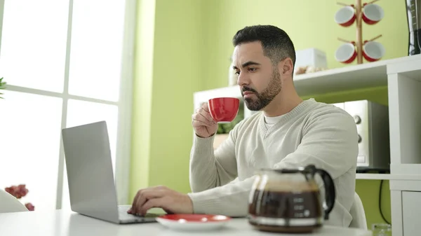 在家里用笔记本电脑喝咖啡的年轻人 — 图库照片