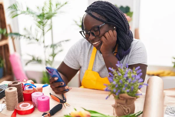 アフリカ系アメリカ人女性花屋でスマートフォンを使用して自信を笑顔 — ストック写真