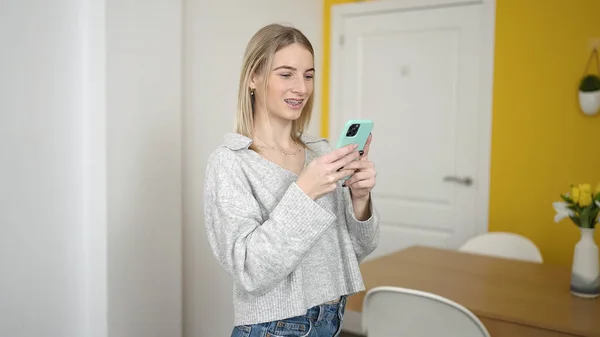 Młoda Blondynka Pomocą Smartfona Domu — Zdjęcie stockowe