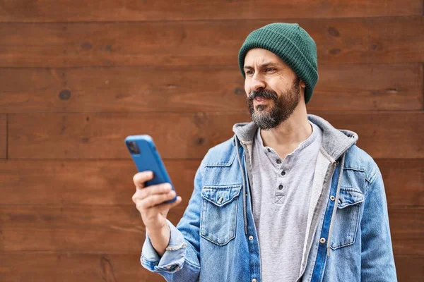 Joven Hombre Hispano Usando Smartphone Con Aspecto Positivo Feliz Pie — Foto de Stock