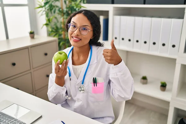 年轻的他的惊慌失措的医生女人 拿着青苹果笑得开心而积极 大拇指向上做得出色 签了字 — 图库照片