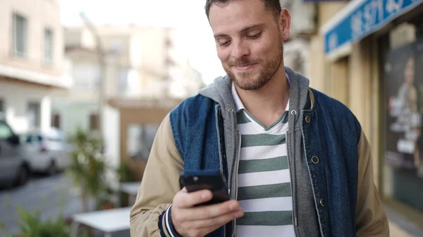 Young Caucasian Man Smiling Using Smartphone Street —  Fotos de Stock